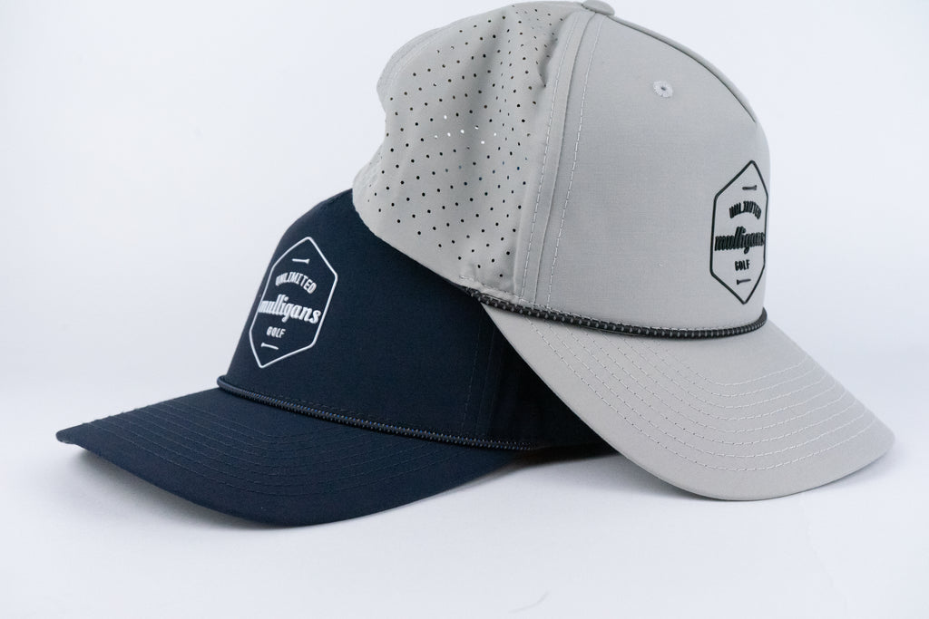 Two rope caps, one navy and one gray, with a visible brand logo for Unlimited Mulligans Golf on a white background.